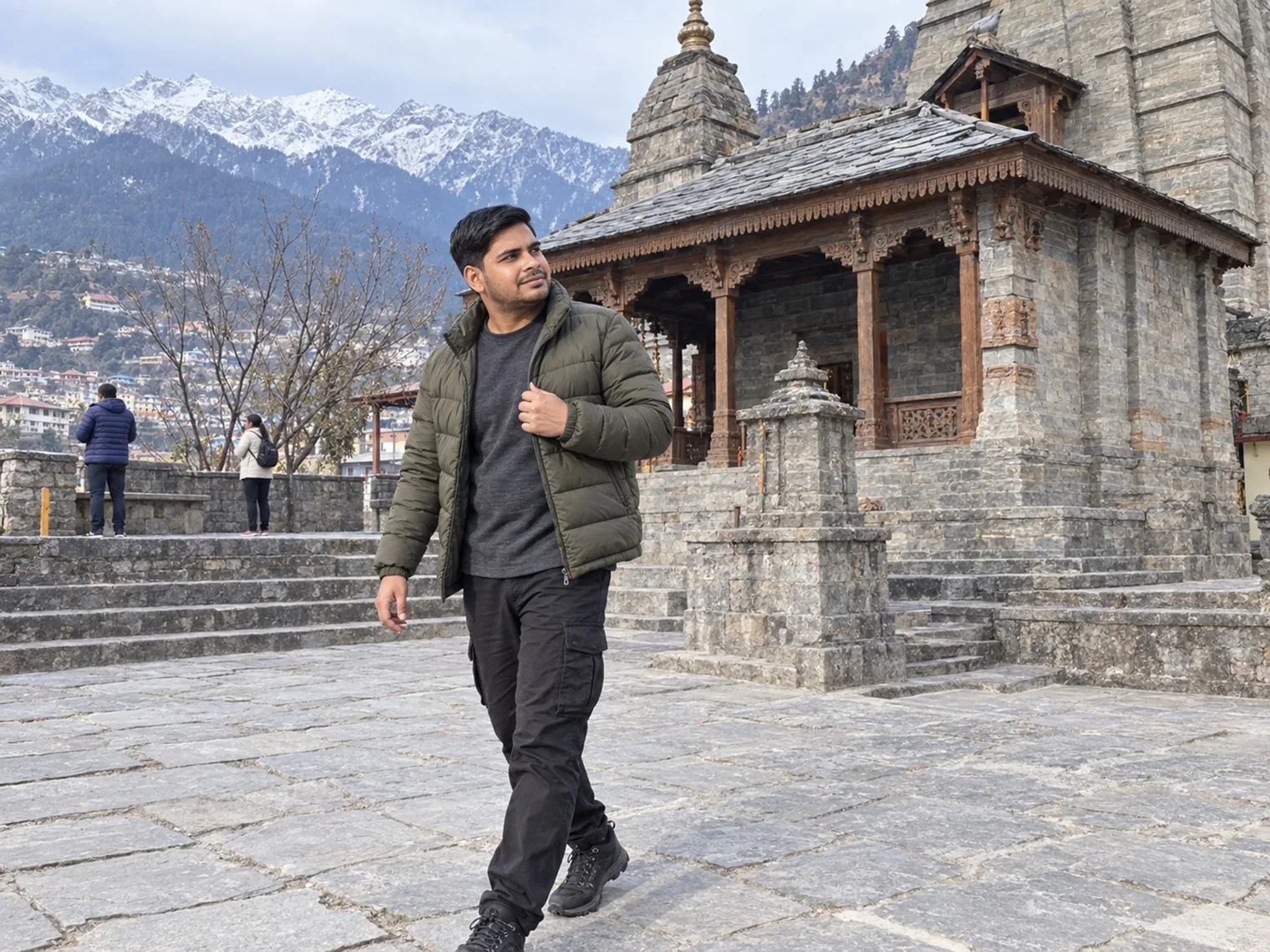 Nav walking past an old stone temple on a paved courtyard, snow-covered peaks in the distance.